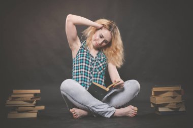 öğrenmek için kitaplar ve çok katta oturan genç ve güzel öğrenci kız yorgun