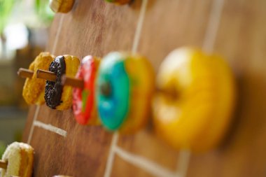 assortment of colorful fresh donuts on a wooden Board for the holiday clipart