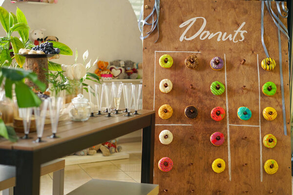 assortment of colorful fresh donuts on a wooden Board for the holiday