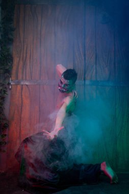 korkutucu vampir erkek büyük dişleri ve kanlı organ olarak gece duman tek başına ayakta Cadılar Bayramı vücut sanatı