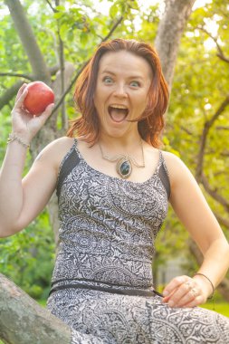 Kızıl saçlı alternatif kız güneşli elma bahçesi traş yürüyüşleri ile bir güneşli yaz gününde gülümseyen