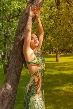 Kızıl saçlı alternatif kız güneşli elma bahçesi traş yürüyüşleri ile bir güneşli yaz gününde gülümseyen