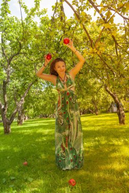 Kızıl saçlı alternatif kız güneşli elma bahçesi traş yürüyüşleri ile bir güneşli yaz gününde gülümseyen