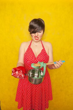 plump girl in a red polka-dot dress stands with an empty pan and a centimeter tape on a spoon, wants to eat, but diets for health and figure clipart