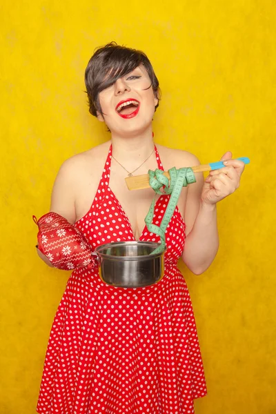 赤い水玉のドレスの少女はふっくら空鍋とスプーンでセンチ テープ スタンド 美容と健康のためのダイエットが食べたいです — ストック写真