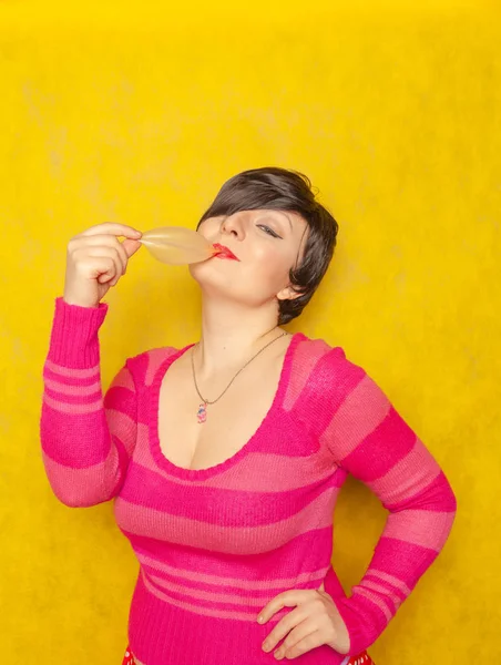 短い髪のかわいい女性がガムを咀嚼し 黄色の背景に泡をパフ — ストック写真