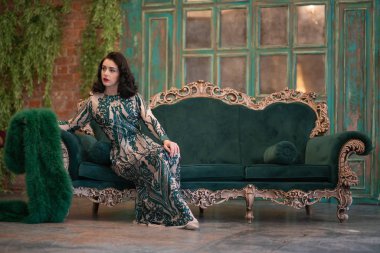 bir lüks uzun pullu dantel şık beyaz kız retro vintage lüks mobilya oda poz onun elinde bir yeşil tüylü boa ile elbise