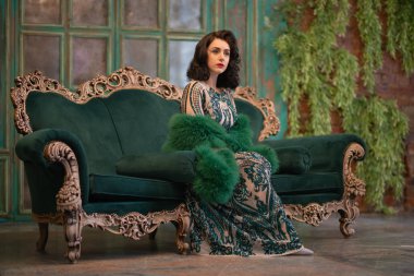 bir lüks uzun pullu dantel şık beyaz kız retro vintage lüks mobilya oda poz onun elinde bir yeşil tüylü boa ile elbise