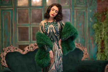 bir lüks uzun pullu dantel şık beyaz kız retro vintage lüks mobilya oda poz onun elinde bir yeşil tüylü boa ile elbise