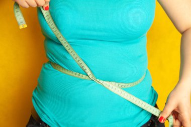tombul kız şişman karnı çevresi tarafından santimetre teyp ölçer.