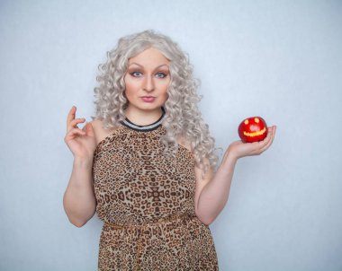 Yazlık elbise giyen ve beyaz arka planda yalnız büyük kırmızı elma ile poz tombul sarışın kız 