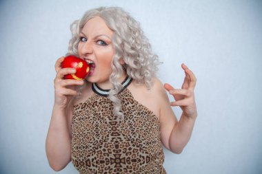 Yazlık elbise giyen ve beyaz arka planda yalnız büyük kırmızı elma ile poz tombul sarışın kız 