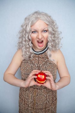 Yazlık elbise giyen ve beyaz arka planda yalnız büyük kırmızı elma ile poz tombul sarışın kız 