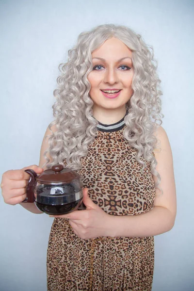 cute caucasian chubby girl with a kettle of freshly brewed coffee in her hands for Breakfast on a white Studio solid background