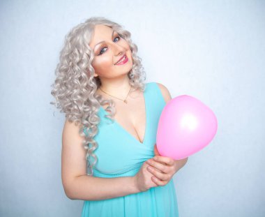 güzel sarışın neşeli kız beyaz stüdyo arka plan üzerinde pembe hava balonu ile