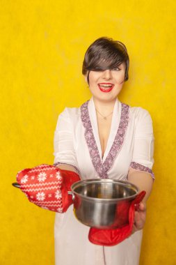 beyaz ev hanımı bir yemek hazırlar. esmer sarı katı Studio arka plan üzerinde tava ve tencere sahipleri ile bir bornoz duruyor.