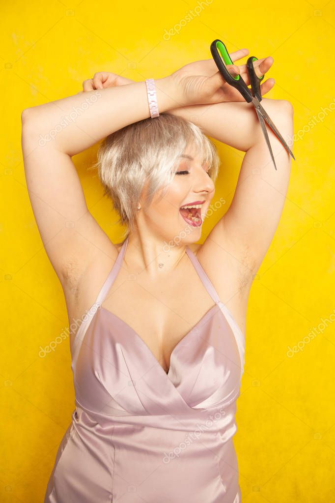 Chubby girl dress with unshaven and scissors in hand on yellow background Studio #250674806 - Larastock