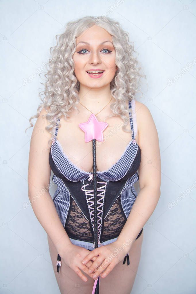 caucasian curvy girl in erotic lingerie with leather bdsm riding crop standing as advanced vanilla person ready for kinky sex on white background