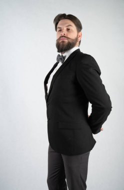 elini ve bir kadeh şarap beyaz sağlam bir arka plan stüdyo üzerinde çelik bir tepsi ile resmi iş takım elbiseli sakallı beyaz hizmetçi duruyor