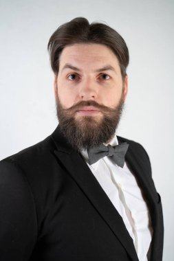 elini ve bir kadeh şarap beyaz sağlam bir arka plan stüdyo üzerinde çelik bir tepsi ile resmi iş takım elbiseli sakallı beyaz hizmetçi duruyor