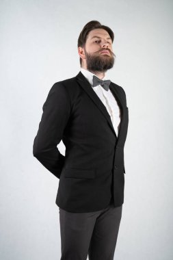 elini ve bir kadeh şarap beyaz sağlam bir arka plan stüdyo üzerinde çelik bir tepsi ile resmi iş takım elbiseli sakallı beyaz hizmetçi duruyor