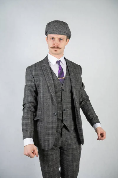 vintage English man with a checkered business suit on a white studio solid background
