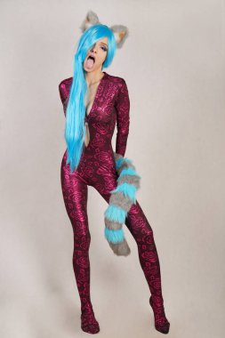 kürk kulakları ve uzun tüylü kuyruğu ile sıradışı bir tulum genç kız cosplay seviyor ve beyaz bir stüdyo arka plan üzerinde duruyor