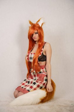 Kızıl saçlı kız kürk kulakları ve kuyruğu mutfak önlük Studio beyaz arka plan üzerinde poz ile