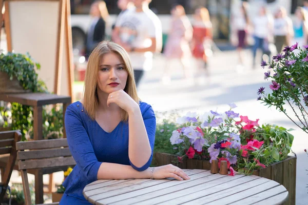 Charmig Kaukasiska Blond Flicka Blå Klänning Som Sitter Vid Ett — Stockfoto