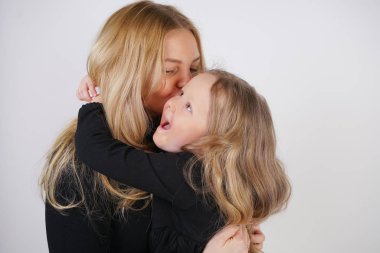 Beyaz arka plan üzerinde poz sevimli tür beyaz Sarışın Anne ve kızı. bir ebeveyn ve çocuk deneyimi sevgi ve sarılmak.