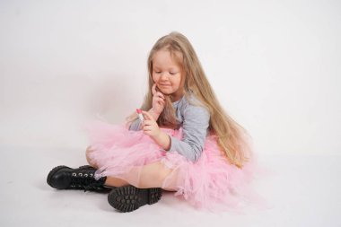 biraz beyaz sarışın kız oturur ve annesinin pembe ruj ile makyaj yapmak ve er bir yetişkin olmak istiyor