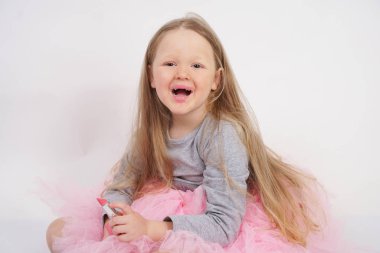 biraz beyaz sarışın kız oturur ve annesinin pembe ruj ile makyaj yapmak ve er bir yetişkin olmak istiyor