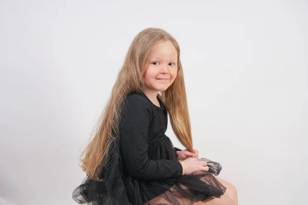 Uzun Sarışın Saçlı Sevimli Küçük Kız Oturur Beyaz Arka Planda — Stok fotoğraf