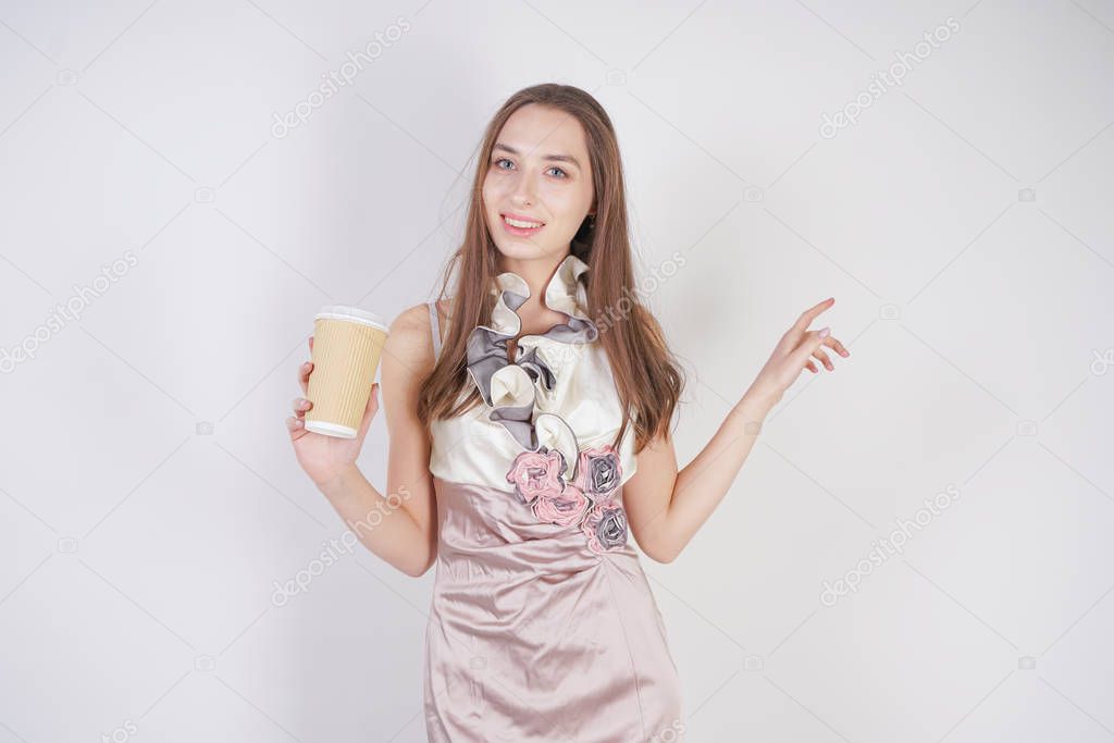 cute teenager caucasian girl in fashionable evening dress with paper coffee Cup on white background in Studio alone