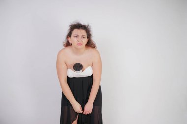 elinde bir kağıt fincan kahve ile tombul kadın baş ağrısı ve yorgunluk muzdarip. Stüdyo beyaz arka planda tombul kız ayakta