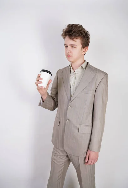 Unavené Dospívající Dítě Šedé Obchodní Obleku Papírovým Šálkem Kávy Bílém — Stock fotografie