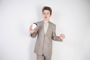 beyaz stüdyo arka plan üzerinde elinde kahve kağıt Fincan ile gri iş elbisesi genç erkek