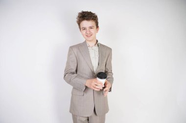 beyaz stüdyo arka plan üzerinde elinde kahve kağıt Fincan ile gri iş elbisesi genç erkek