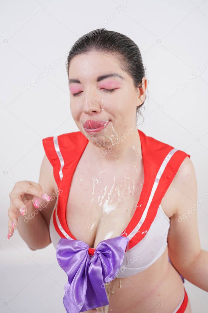 sexy chubby woman with big tits dressed in cosplay school uniform and doused with condensed milk on a white background in the Studio