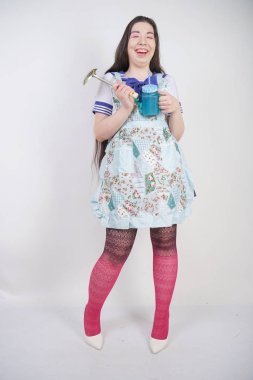 Stüdyo beyaz arka plan üzerinde anime okul üniforması ve mutfak önlüğü büyüleyici esmer pişirme kız