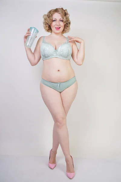 Красивая белая пухленькая женщина с телом и бледной кожей в зеленом кружеве сексуальное белье на белом фоне студии — стоковое фото