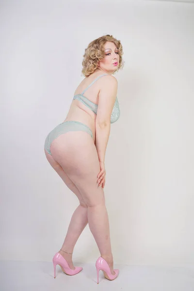 Mooie Kaukasische Mollige vrouw met plus grootte lichaam en bleke huid dragen groene kant sexy ondergoed op witte studio achtergrond — Stockfoto