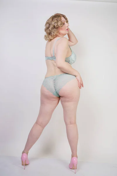 漂亮的白种人胖子妇女加大小身体和苍白的皮肤穿绿色蕾丝性感内衣的白色工作室背景 — 图库照片
