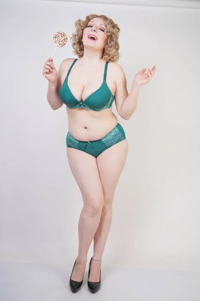 Beautiful young caucasian chubby woman with plus size body and pale skin wearing lace sexy lingerie on white studio background alone