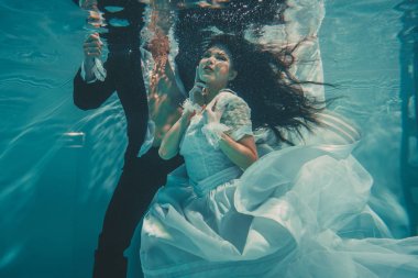 gelin ve damat güzel romantik çift düğün den sonra su altında yavaşça yüzme ve dinlenmek