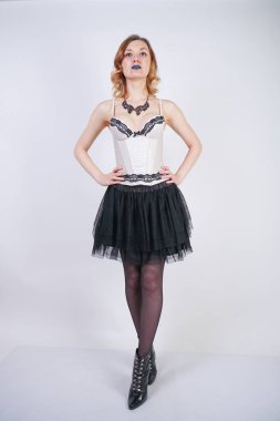 Studio beyaz arka plan üzerinde dantel bej iç çamaşırı korse ve siyah etek büyüleyici kafkas sarışın