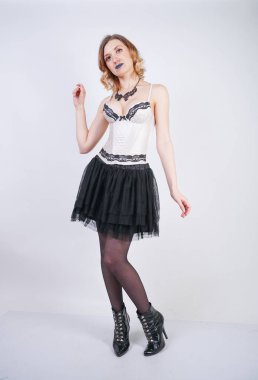 Studio beyaz arka plan üzerinde dantel bej iç çamaşırı korse ve siyah etek büyüleyici kafkas sarışın