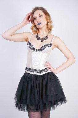 Studio beyaz arka plan üzerinde dantel bej iç çamaşırı korse ve siyah etek büyüleyici kafkas sarışın