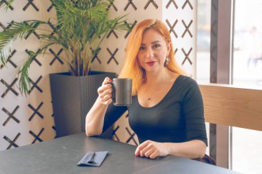 siyah gömlekli kızıl saçlı beyaz kadın sadece modern kafede kahve fincan ıstabiridir