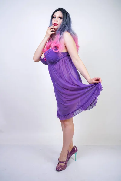迷人的 Buxom 女孩站在紫色透明睡衣内衣在工作室的白色背景 — 图库照片